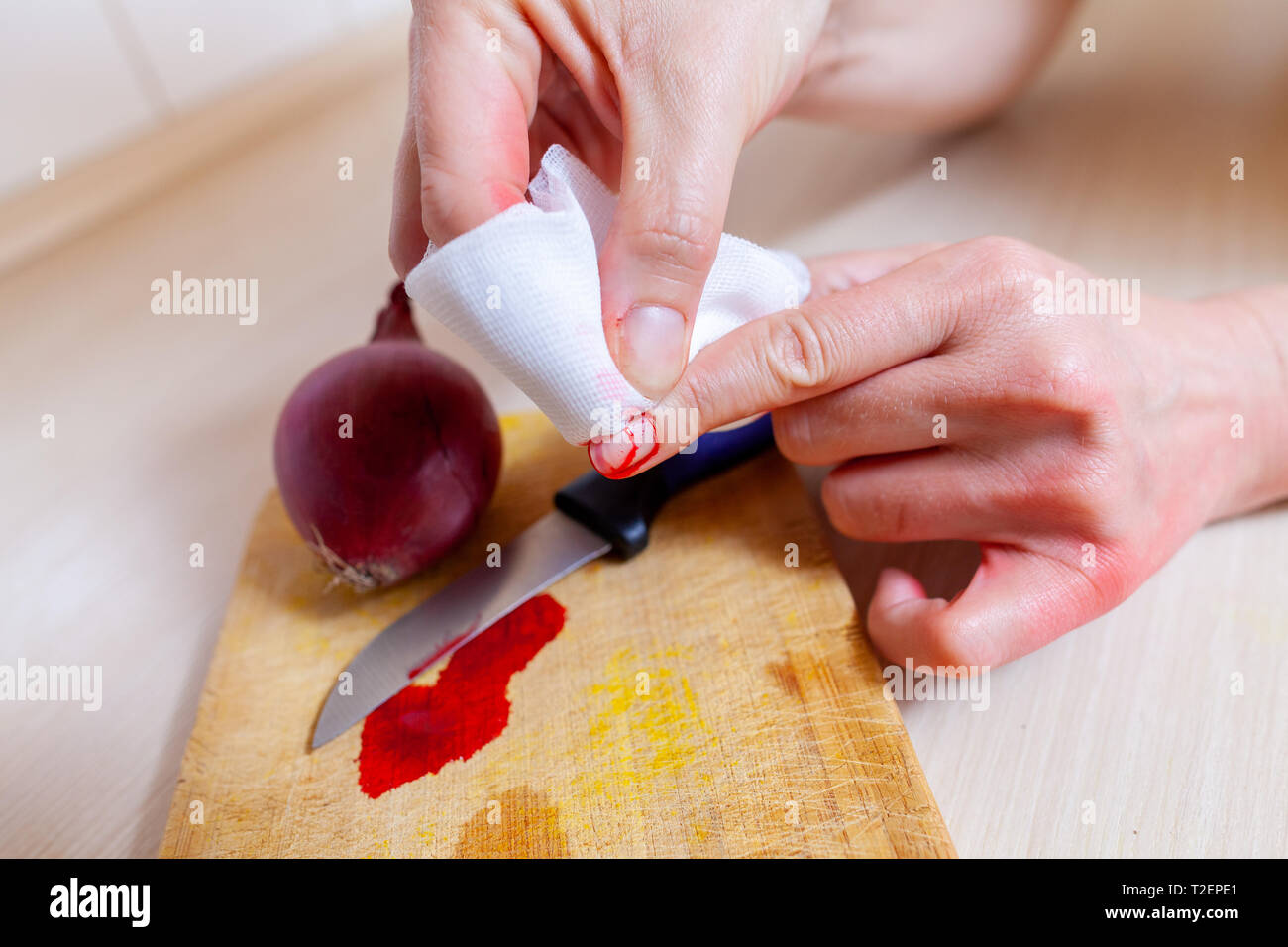 Une femme se coupe avec un couteau dans la cuisine Banque D'Images