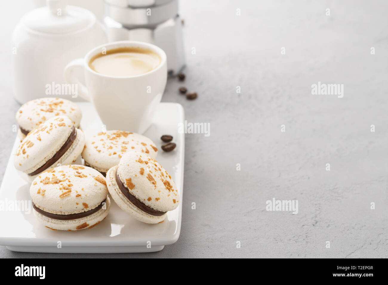 Macarons au chocolat et une tasse de café. Pause café concept. Fond gris. L'espace pour le texte. Banque D'Images