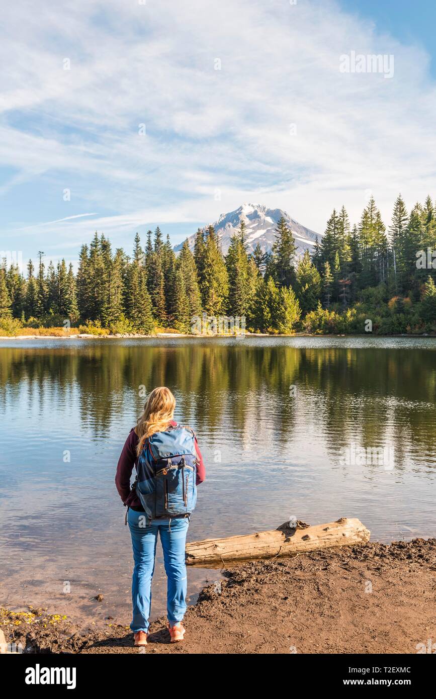 Jeune femme, randonneur regardant le lac Miroir avec forêt, sommet du volcan retour Mt Hood, Oregon, USA Banque D'Images