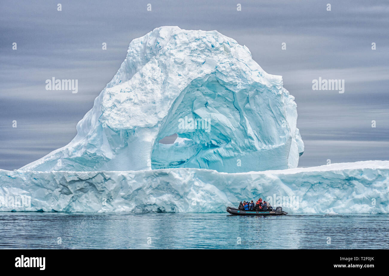 Les passagers d'une croisière zodiac en Antarctique en profitant de la vue d'un énorme iceberg tandis que sur une expédition croisière pour la région polaire Banque D'Images