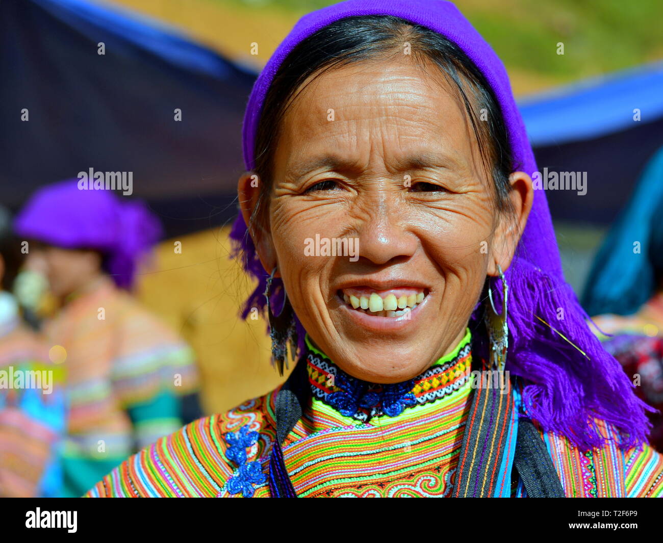 Vietnamiens âgés des H'Mong femme porte une fleur traditionnelle colorée robe H'Mong et sourit pour la photo. Banque D'Images
