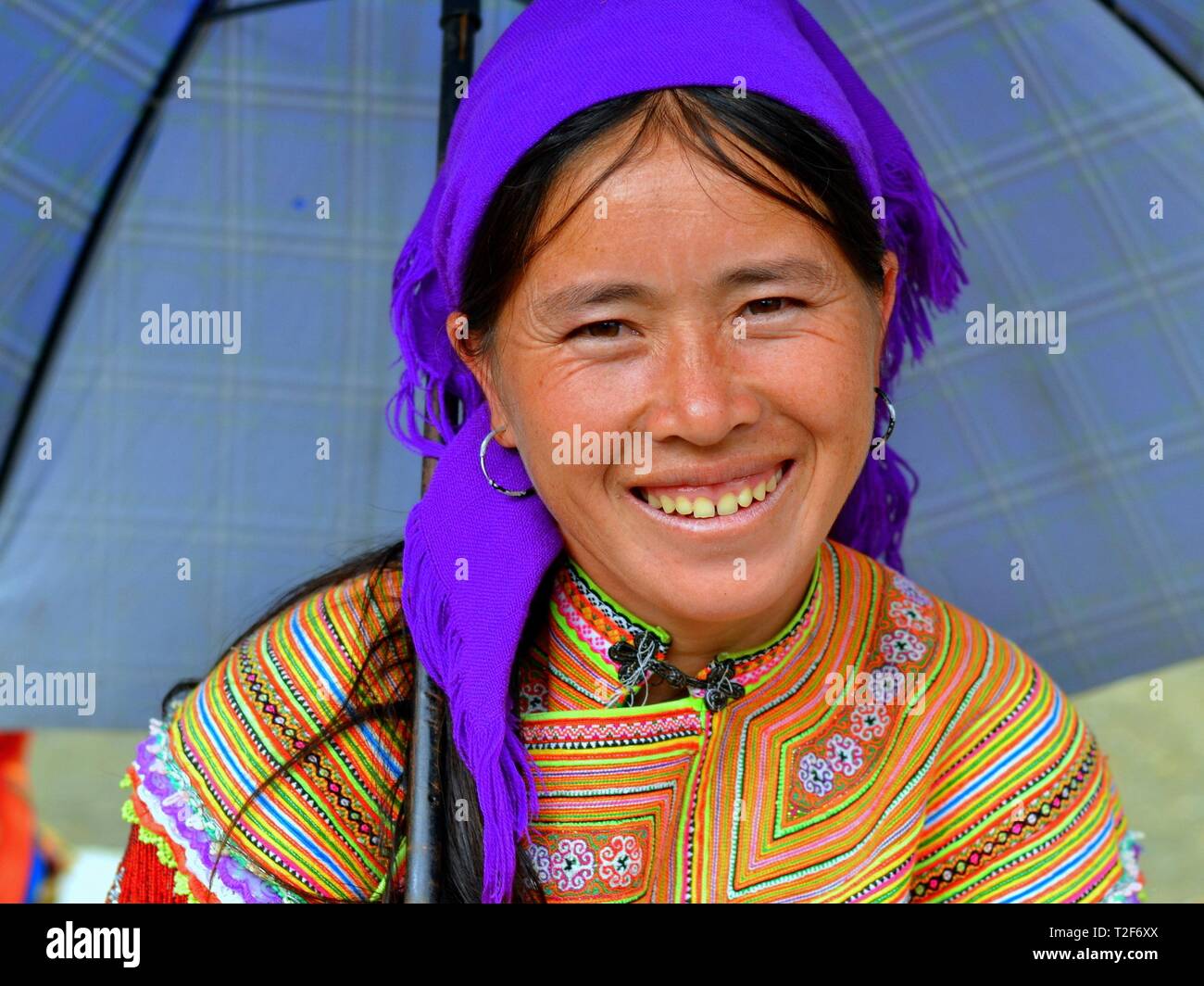 Jeunes vietnamiens des H'Mong femme porte une fleur traditionnelle colorée robe H'Mong et pose sous son parapluie. Banque D'Images