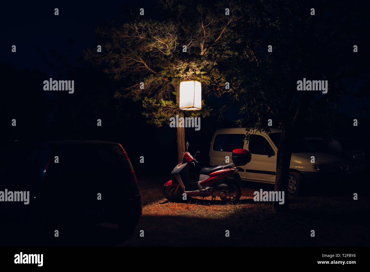 Moto cyclomoteur stationné sous la lanterne de nuit à Ibiza Banque D'Images