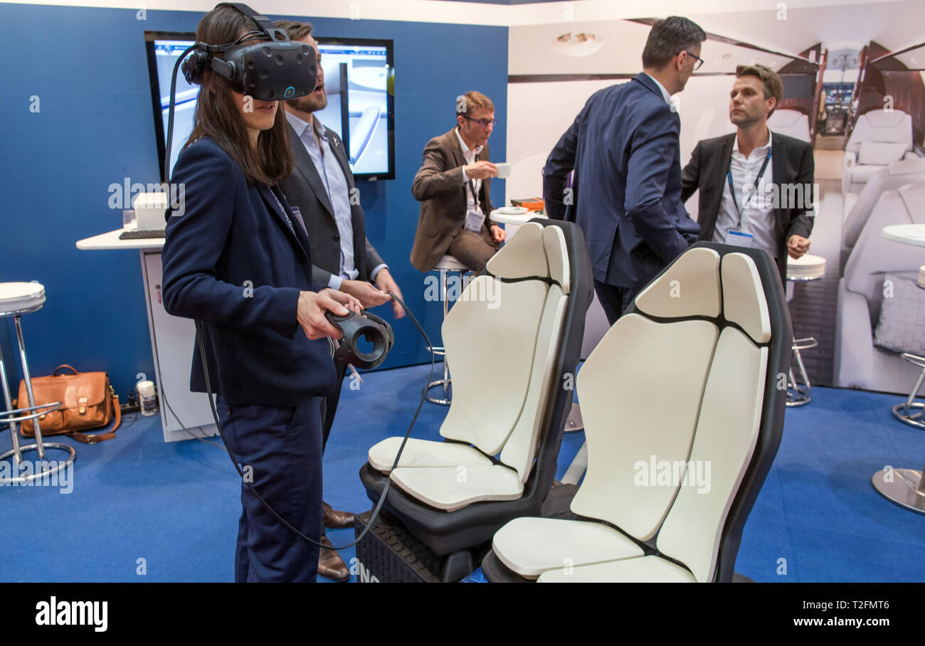 Hambourg, Allemagne. Apr 02, 2019. Un invité à l'Aircraft Interiors Expo est à l'aide de lunettes virtuelles pour voir les sièges d'avion produits dans une imprimante 3D à l'Dassault Systèmes support. Le premier imprimé entièrement en 3D-sièges d'avion sont de 50  % plus léger et équipé de nombreuses fonctionnalités supplémentaires telles que la charge inductive pour téléphones mobiles. Plus de 500 exposants présents nouvelles et innovations pour la cabine de l'avion à la foire. Credit : Jens Büttner/dpa-Zentralbild/dpa/Alamy Live News Banque D'Images