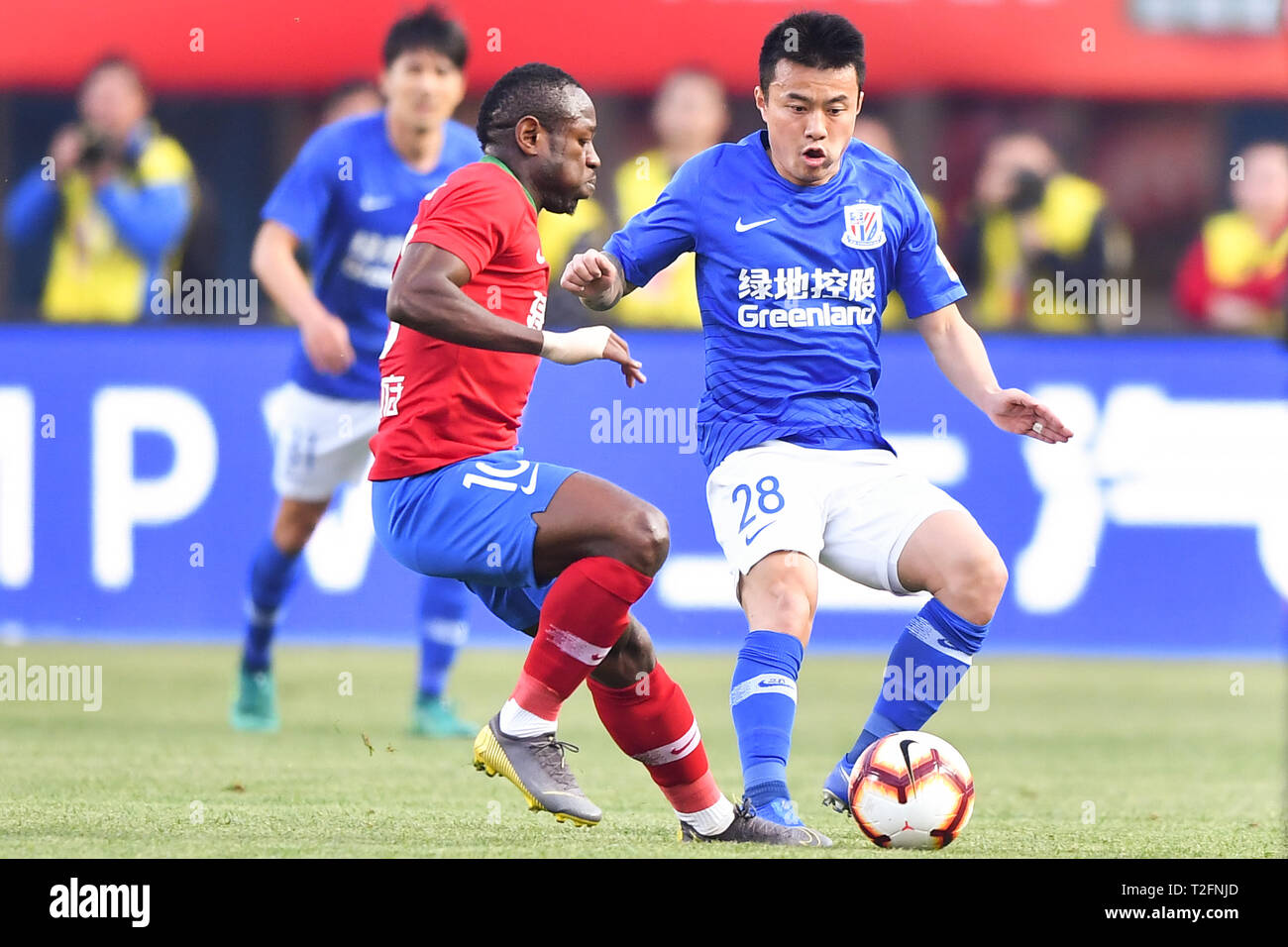 Zhengzhou, Chine. Mar 31, 2019. Joueur de football camerounais Christian Bassogog, gauche, de Henan Jianye défis un joueur de Shanghai Shenhua le Groenland dans leur 3e match au cours de la Football Association Chinoise 2019 Super League (CSL) dans la ville de Zhengzhou, province du Henan en Chine centrale, le 31 mars 2019. Groenland Shanghai Shenhua Henan Jianye défait 2-1. Crédit : Matt Buxton/Alamy Live News Banque D'Images