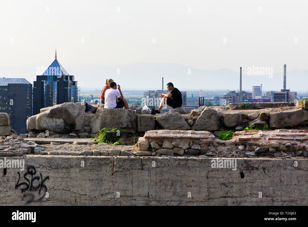 Jeunes assis sur quelques ruines sur la colline de Nebet Tepe surplombant la ville de Plovdiv, Bulgarie Banque D'Images