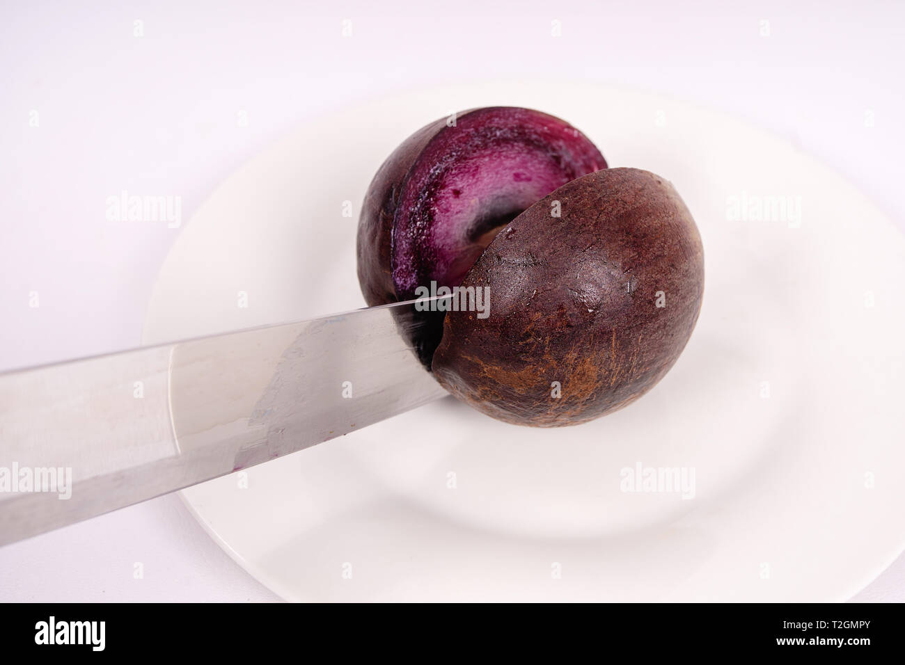 Caimito un fruit coupé en deux par un couteau Banque D'Images