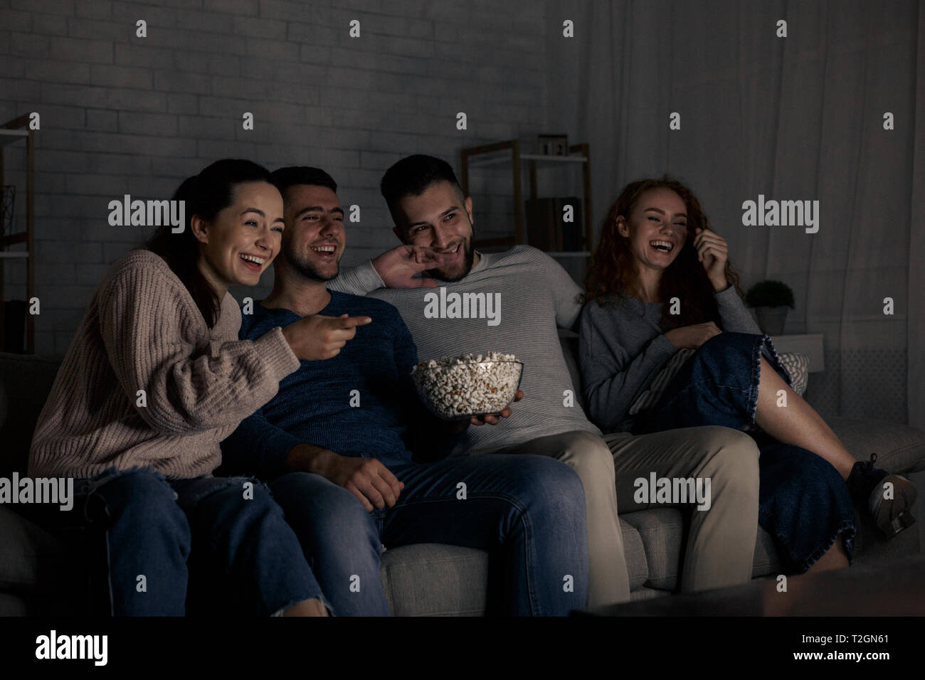 Happy friends watching comédie film et de rire, de détente à la maison ensemble Banque D'Images