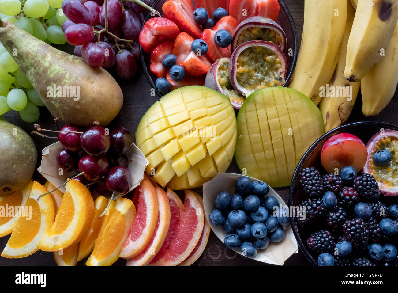 Plateau de fruits colorés dont la mangue, les oranges, les bleuets, les bananes et les poires. Banque D'Images