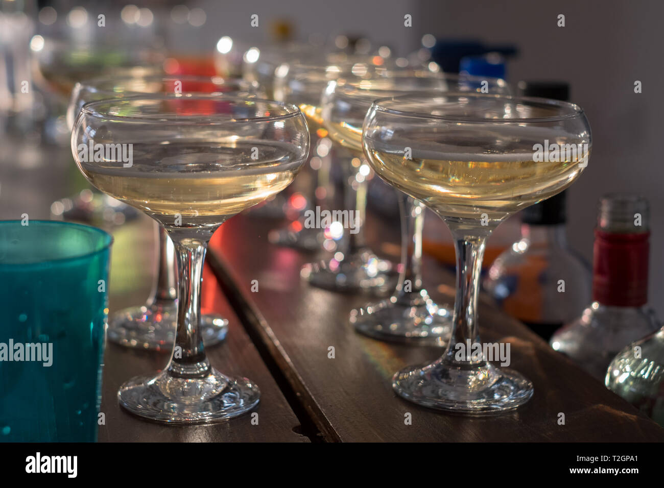 Verres de champagne alignés sur un bar. Des bulles dans l'arrière-plan flou Banque D'Images