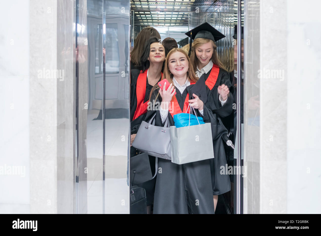 Kharkov, Ukraine - le 27 novembre 2018 : Groupe d'apprenants de sexe féminin dans des robes gaies avec des sacs dans l'ascenseur de l'université Banque D'Images