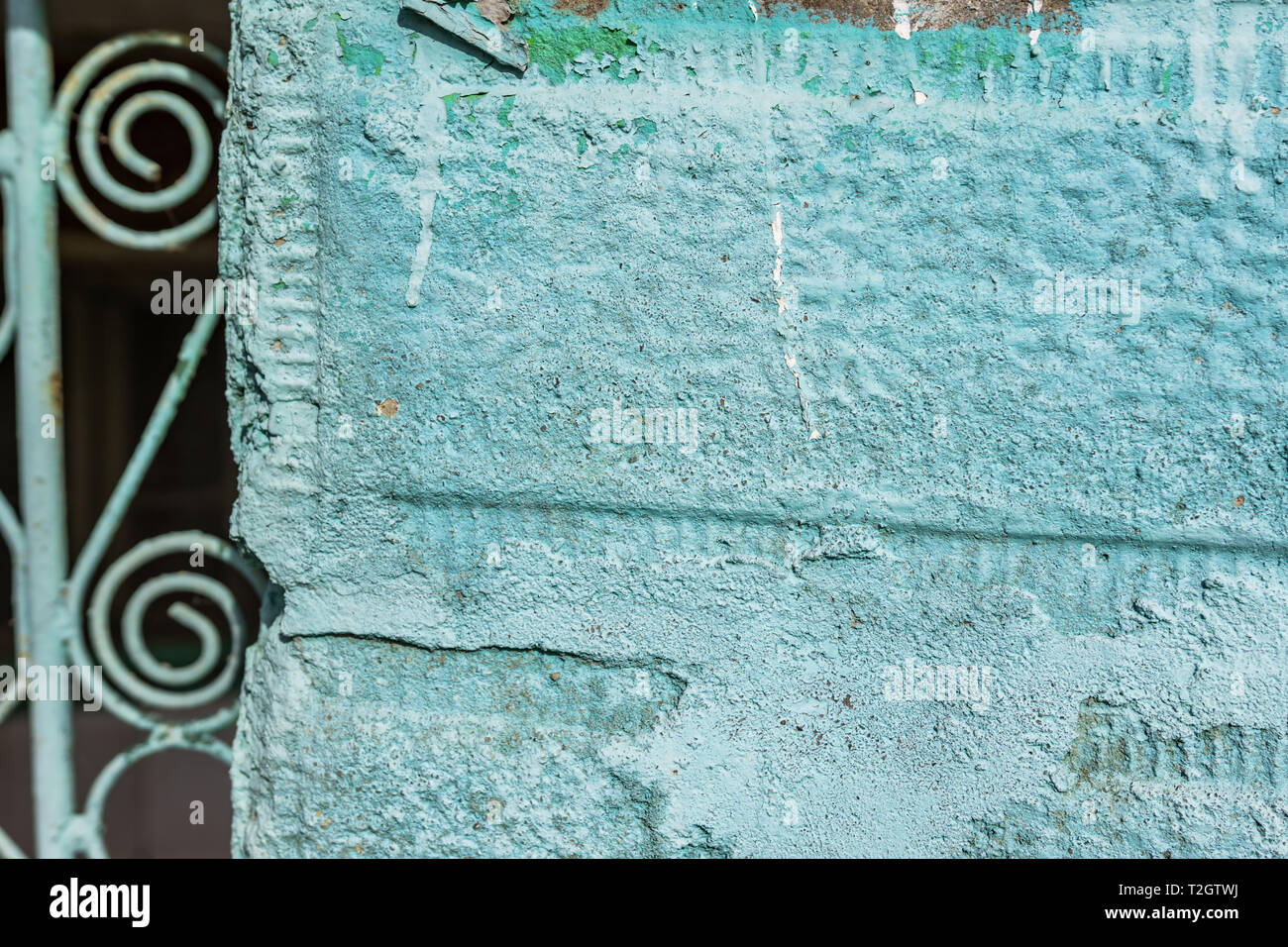 Un gros plan d'un fragment d'une vieille porte en milieu rural. La clôture en pierres peintes en vert et porte de métal avec des ornements. Peu de profondeur de foyer, la texture, l'arrière-plan Banque D'Images