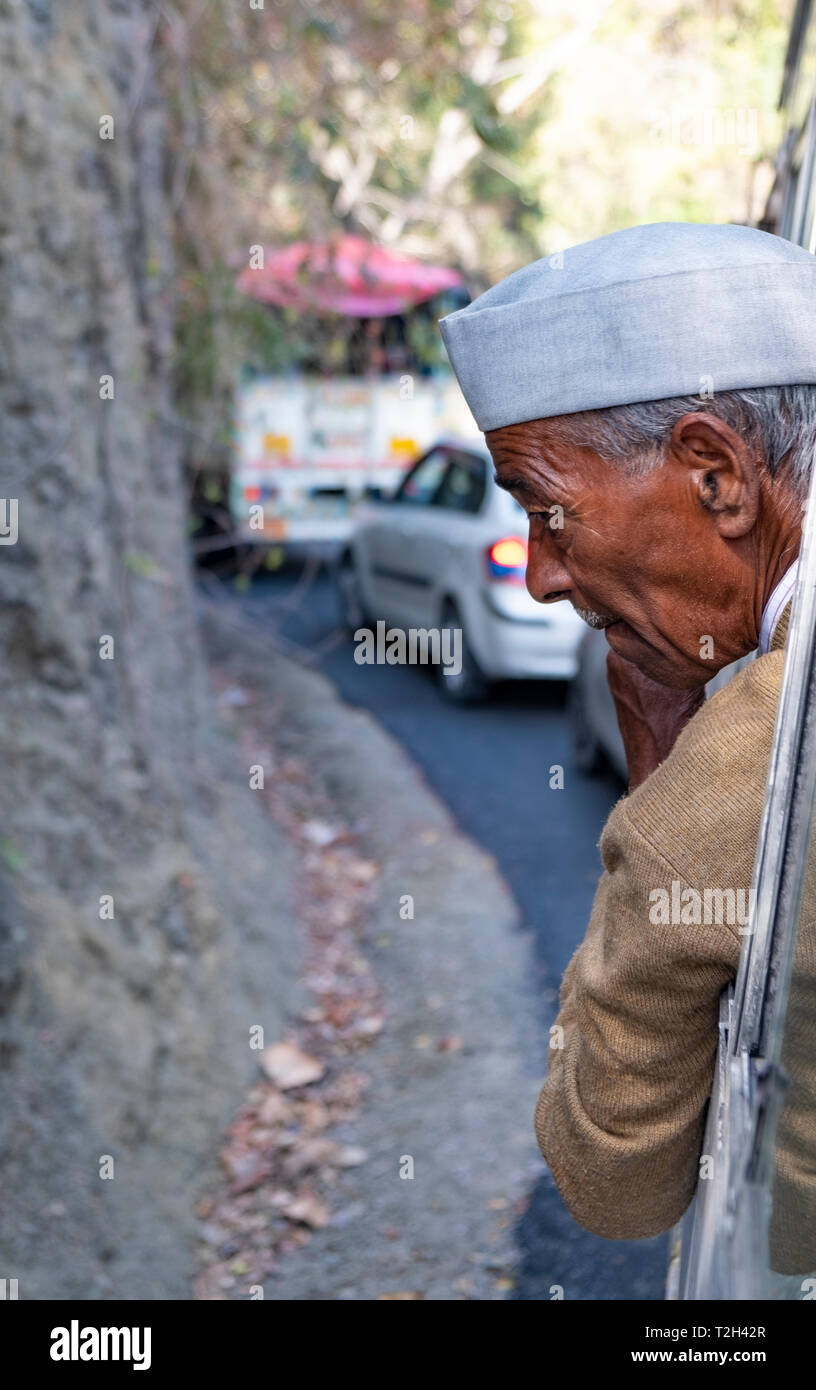 Un vieil homme à la recherche d'une fenêtre sur un autobus en mouvement. Banque D'Images