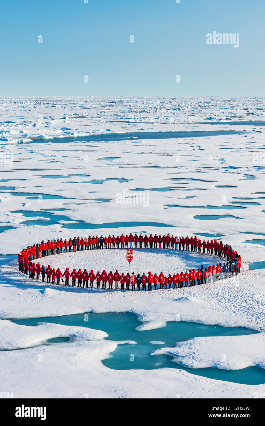 Les personnes portant des vêtements rouges formant cercle autour de l'Arctique, Pôle Nord Banque D'Images