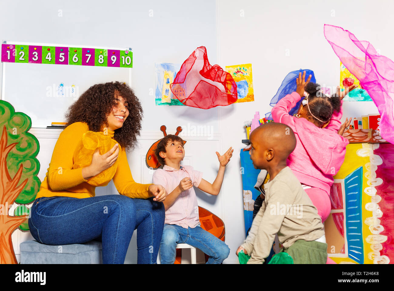 Groupe d'enfants jeter mouchoir en fun jeu de perfectionnement dans la  classe de maternelle Photo Stock - Alamy