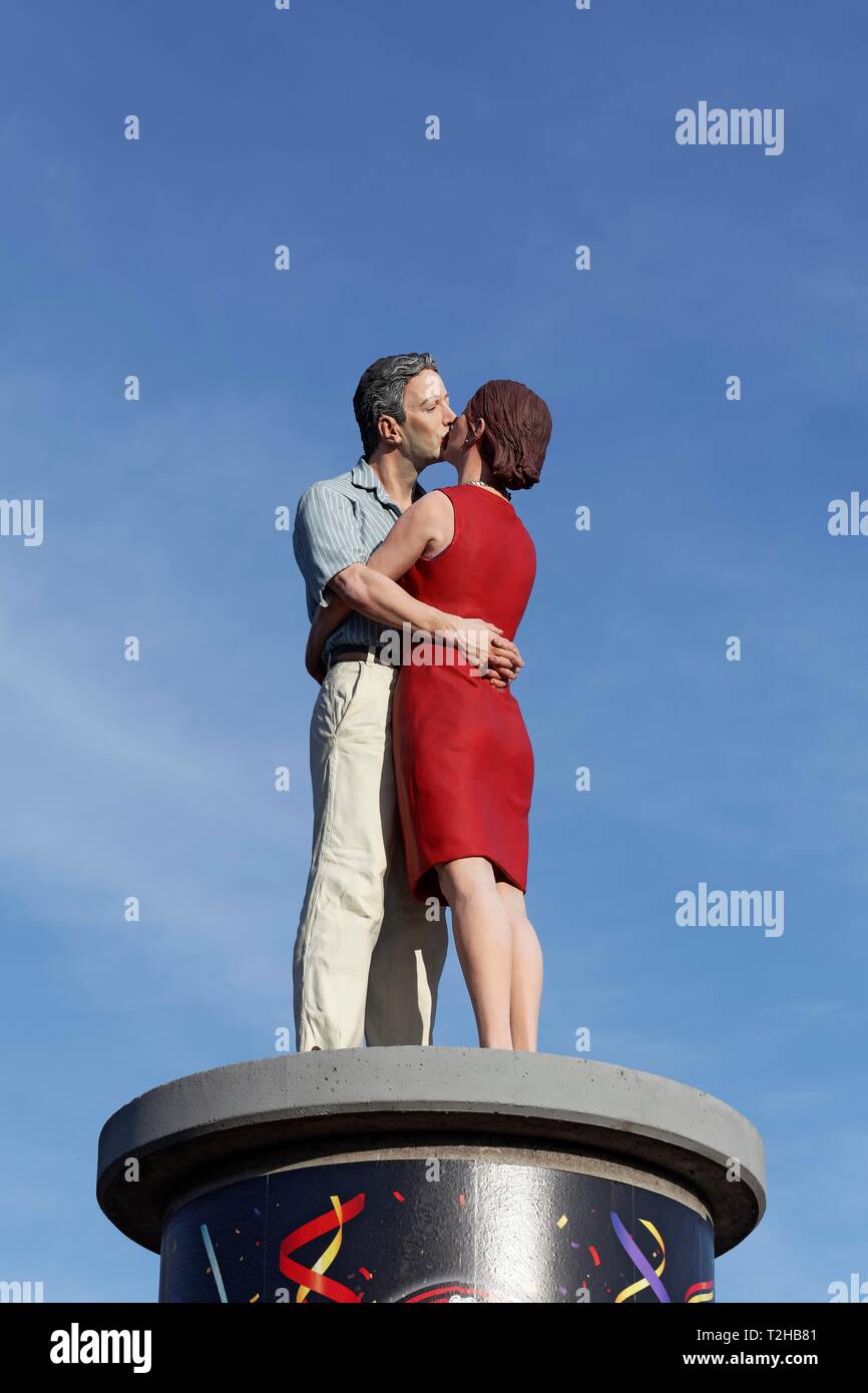 Kissing couple sur un pilier de la publicité en face d'un ciel bleu, la sculpture réaliste par Christoph Poggeler, Düsseldorf, Rhénanie du Nord-Westphalie Banque D'Images