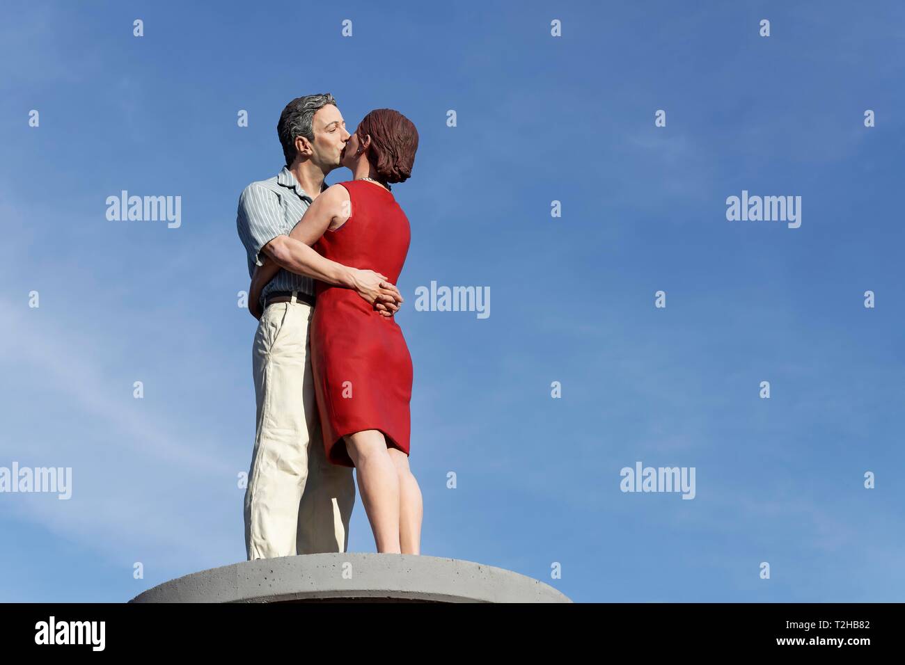 Kissing couple sur un pilier de la publicité en face d'un ciel bleu, la sculpture réaliste par Christoph Poggeler, Düsseldorf, Rhénanie du Nord-Westphalie Banque D'Images