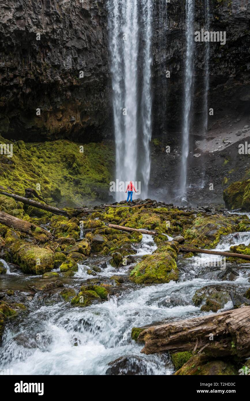 Randonneur en face d'une cascade haute de l'eau, tombe sur un éperon rocheux, danses tamanawas Falls, Fleuve sauvage Cold Spring Creek, Oregon, USA Banque D'Images