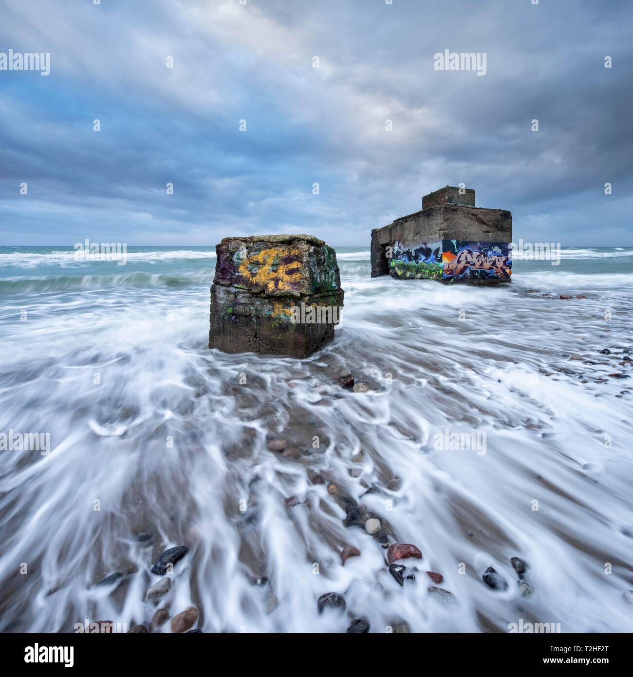 Vieux bunkers de graffitis dans les vagues de la mer Baltique en dessous de la côte escarpée de mer agitée, de haute mer, station balnéaire de la péninsule de Wustrow, Banque D'Images