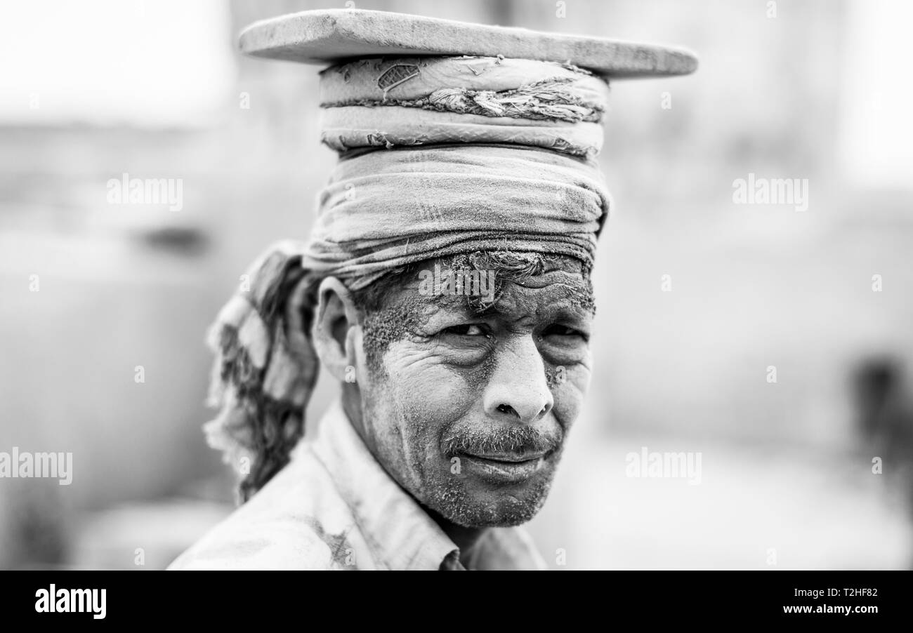 Portrait d'un travailleur, le port de briques sur sa tête, noir et blanc, briqueterie, Dhaka, Bangaladesch Banque D'Images