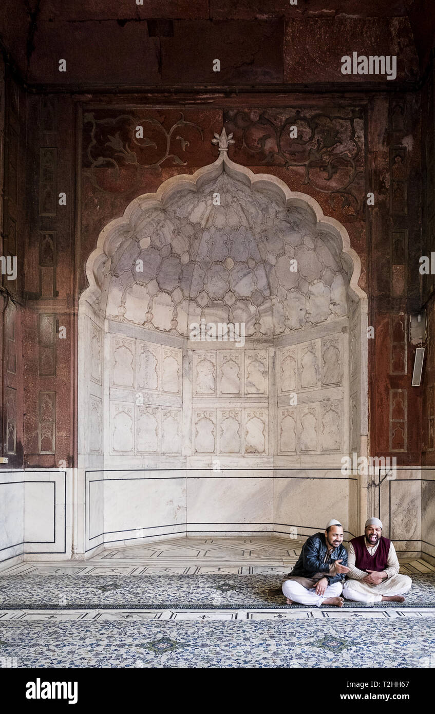 Les hommes assis par arch à la mosquée Jama Masjid de Delhi, Inde, Asie Banque D'Images