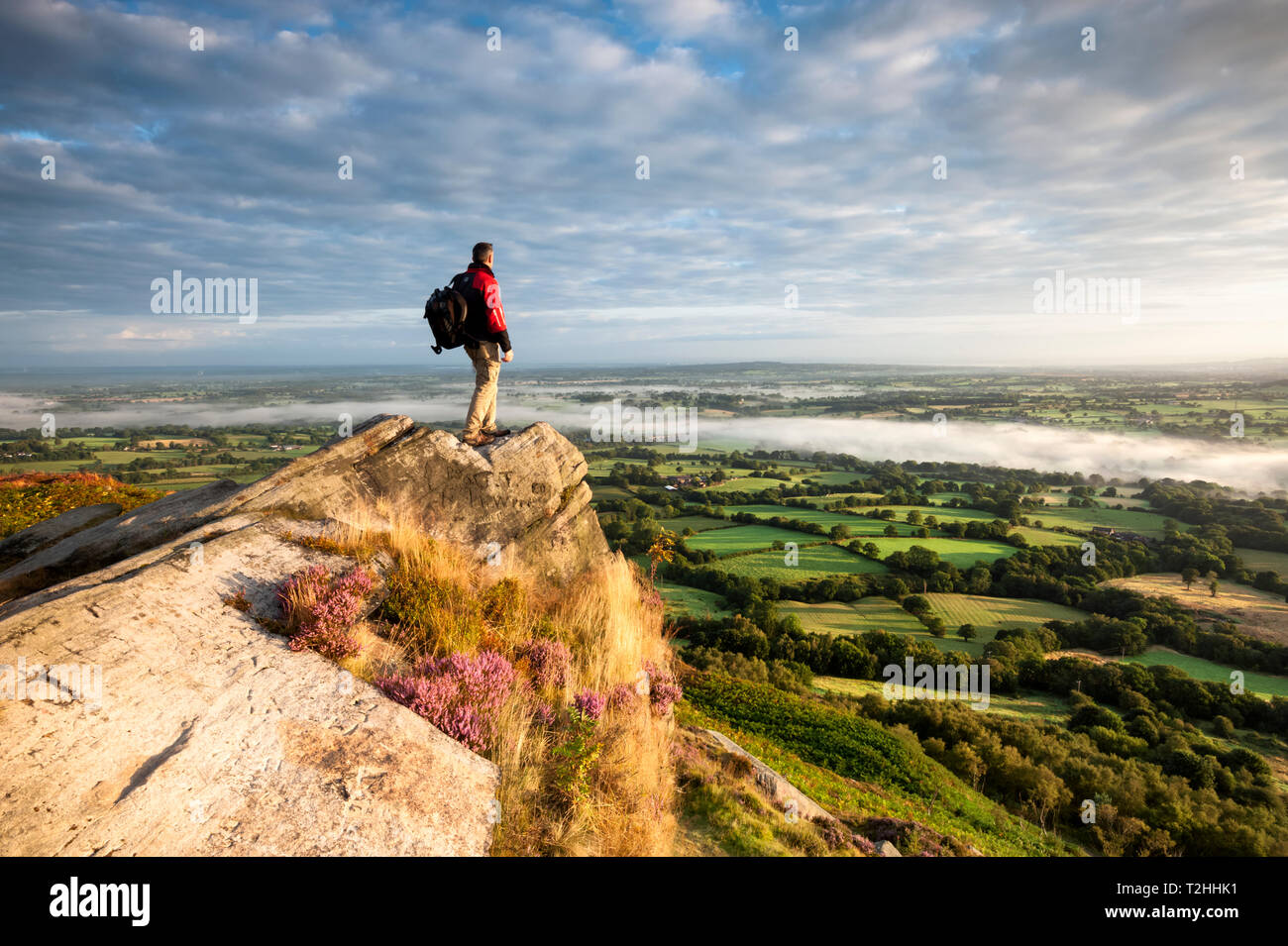 Randonneur sur rocher au-dessus des plaines du Cheshire, Cloudside près de Crewe, Cheshire, Angleterre, Royaume-Uni, Europe Banque D'Images