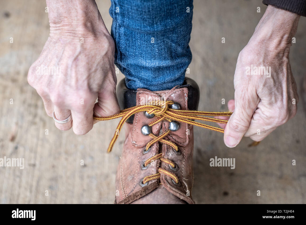 Woman's hands tire lacets serrés sur ses bottes de travail, Fallston, Maryland Banque D'Images
