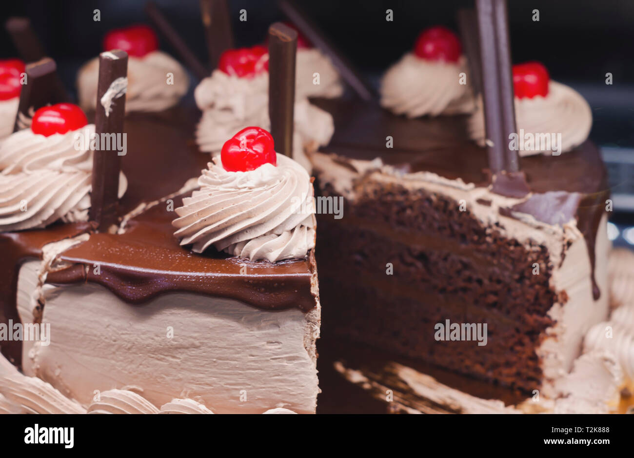 Gâteau au chocolat décoré avec des crèmes et des cerises à vendre Banque D'Images
