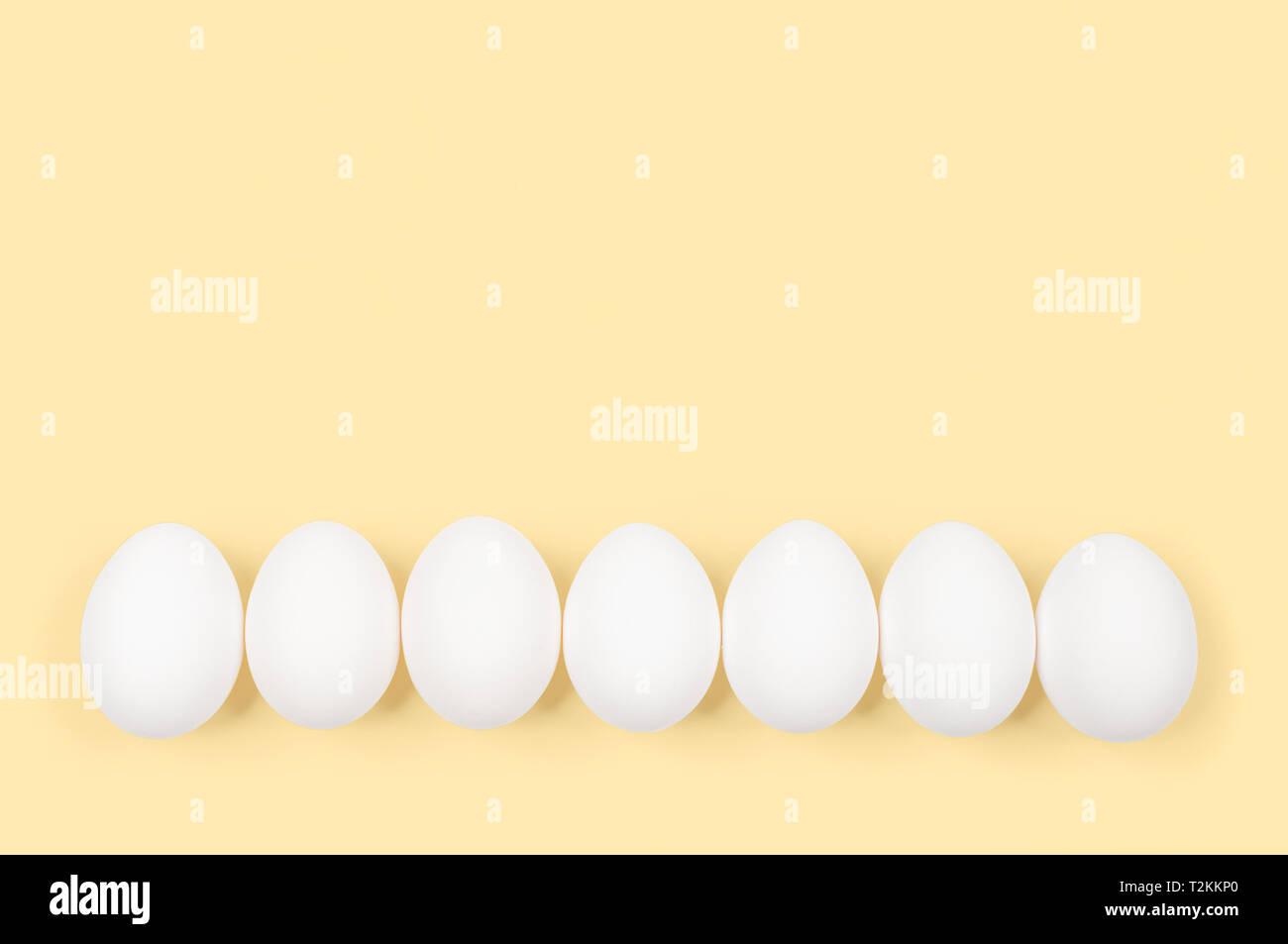 White egg. Des œufs crus sur fond jaune pastel. Concept joyeuses Pâques. Banque D'Images