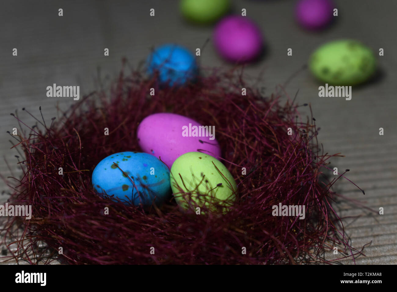 L'omble de bonbons colorés oeufs dans un nid rouge Banque D'Images