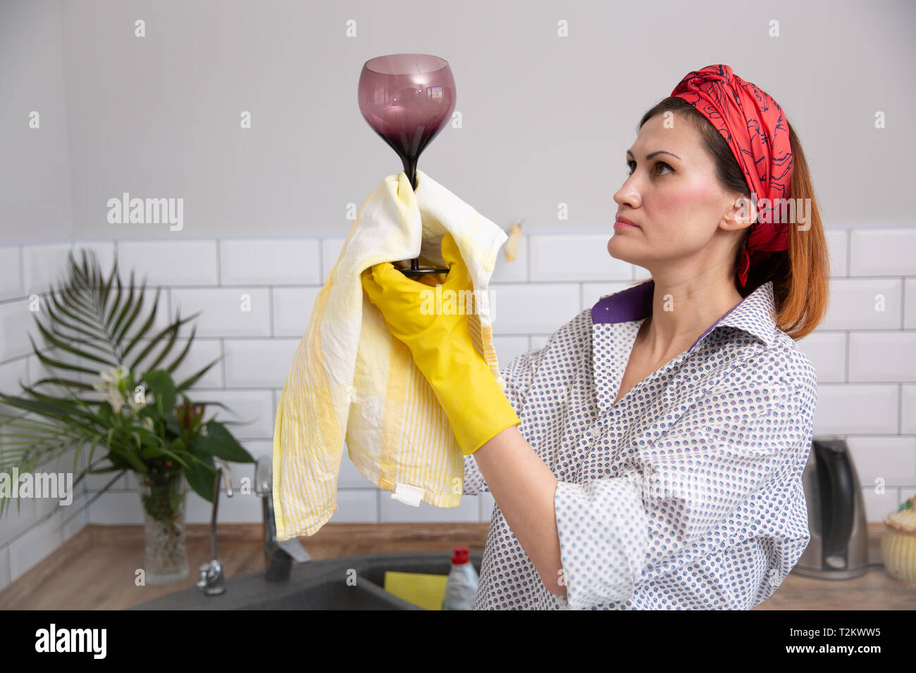 De nettoyage ou de femme verre ruges dans la cuisine. de ménage faire le nettoyage de printemps Banque D'Images