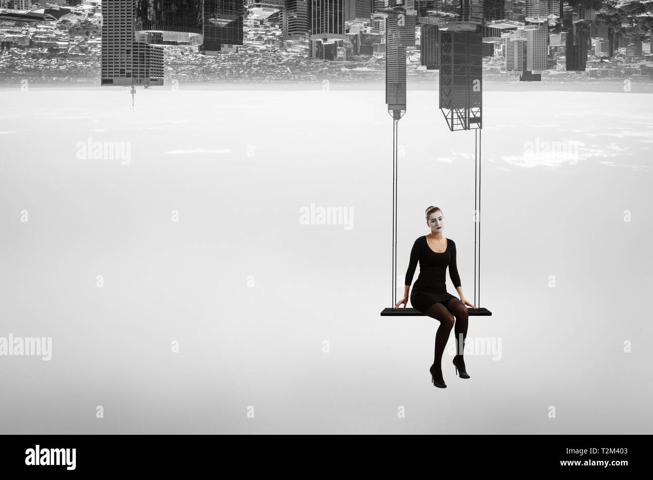 Femme mime dans un costume noir assis sur swing. Technique mixte Banque D'Images