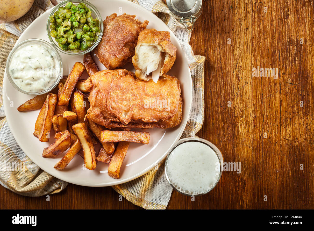 Le poisson dans la pâte traditionnelle de la bière et des frites avec petits pois et sauce tartare.vue d'en haut Banque D'Images