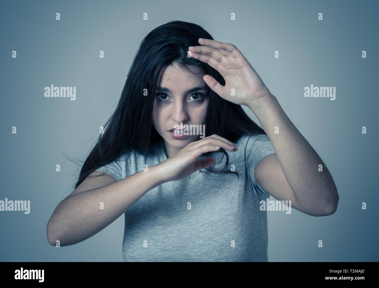 Jeune femme peur et choqué de faire peur, d'anxiété de gestes. À la terreur et à l'couvrant elle-même de une agression. Copier l'espace. Les gens ne Banque D'Images