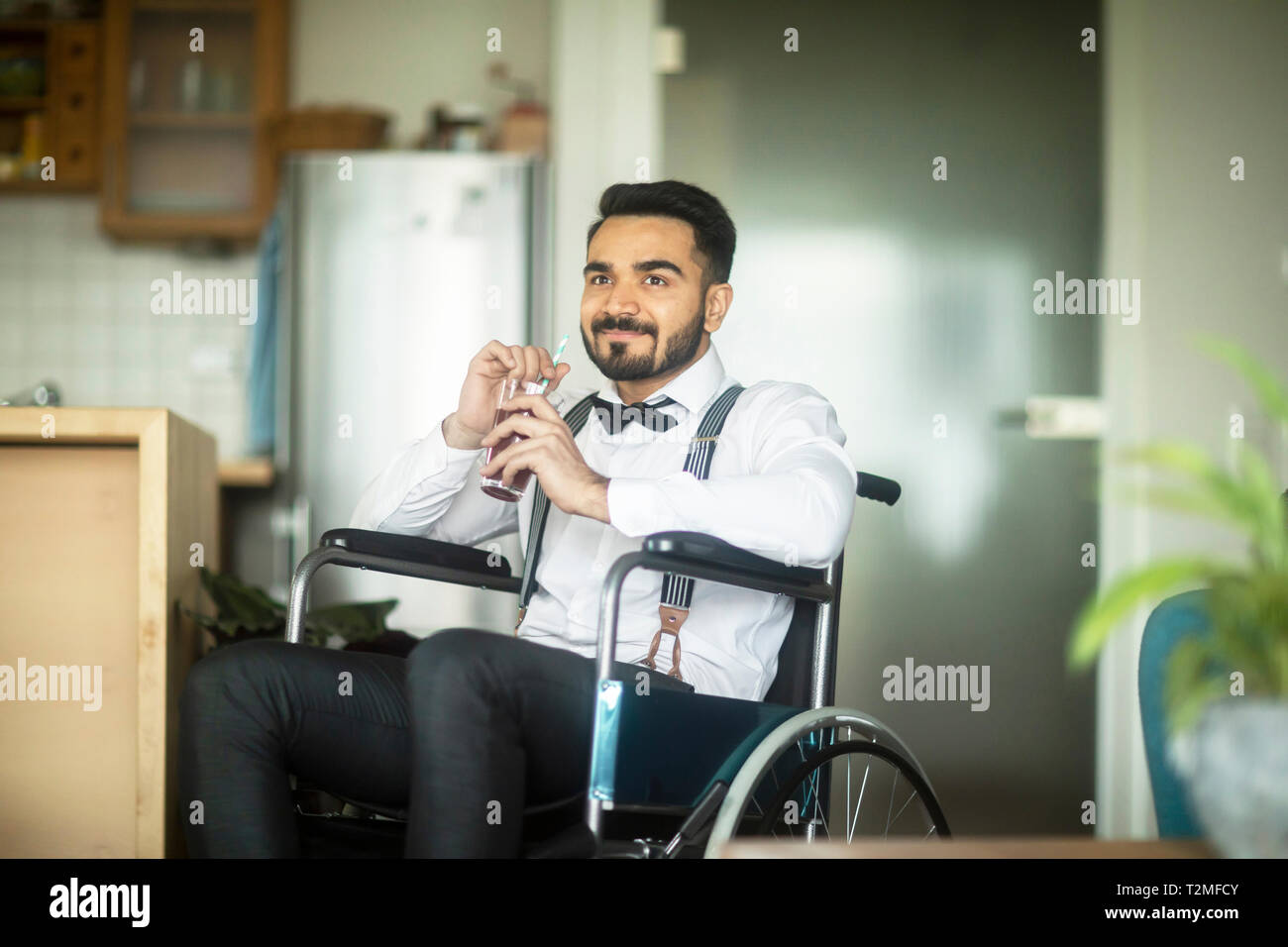 Businessman having drink in wheelchair Banque D'Images