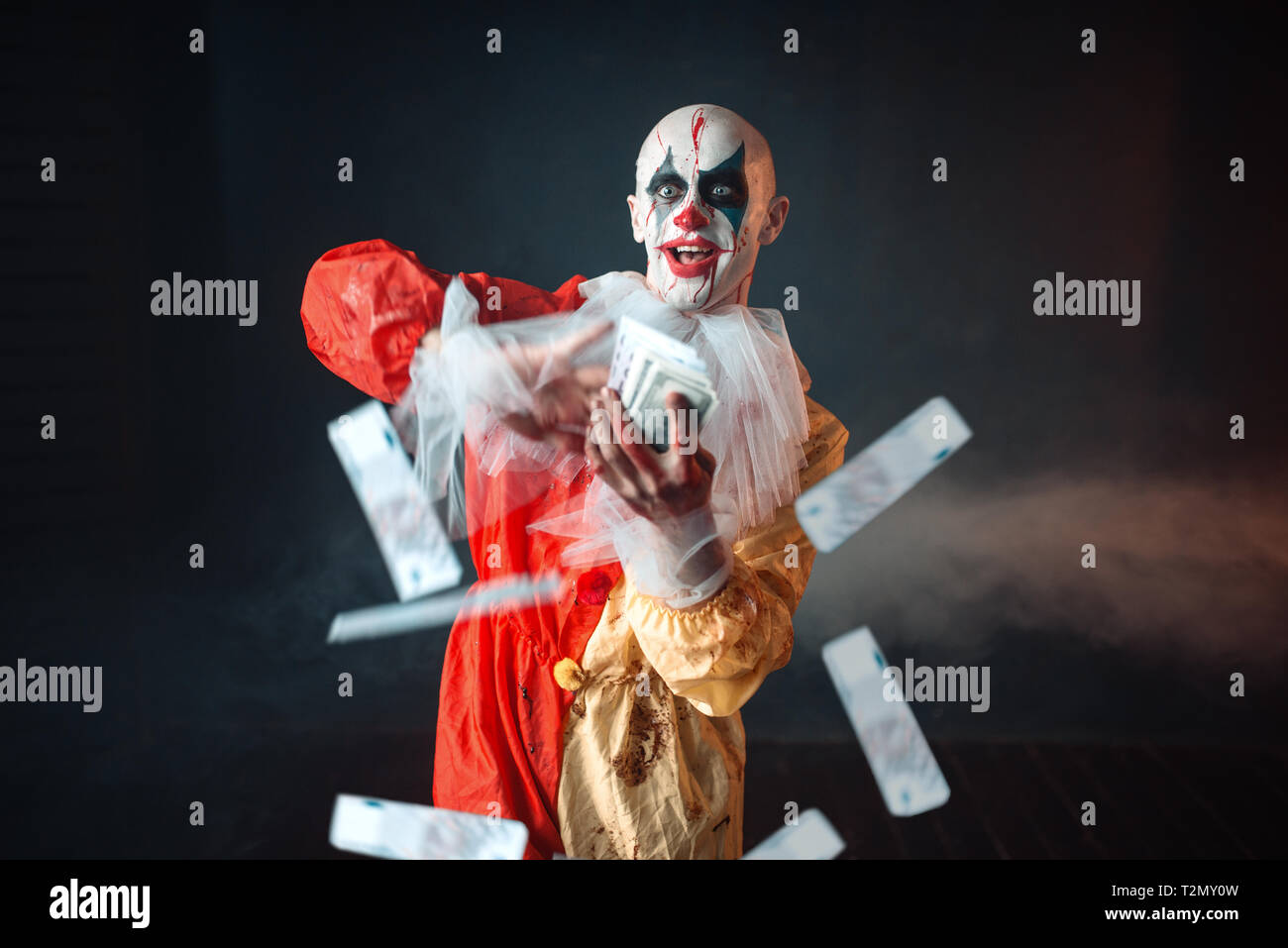Scary clown sanglant avec crazy eyes est titulaire d'argent. ventilateur Avec l'homme en costume maquillage carnaval, mad maniac Banque D'Images