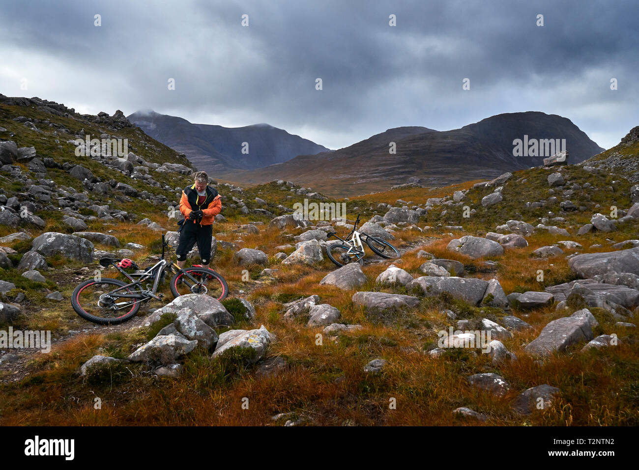 Vélo de montagne mâle en faisant une pause dans la vallée de montagne, paysage, Achnasheen Highlands, Ecosse Banque D'Images