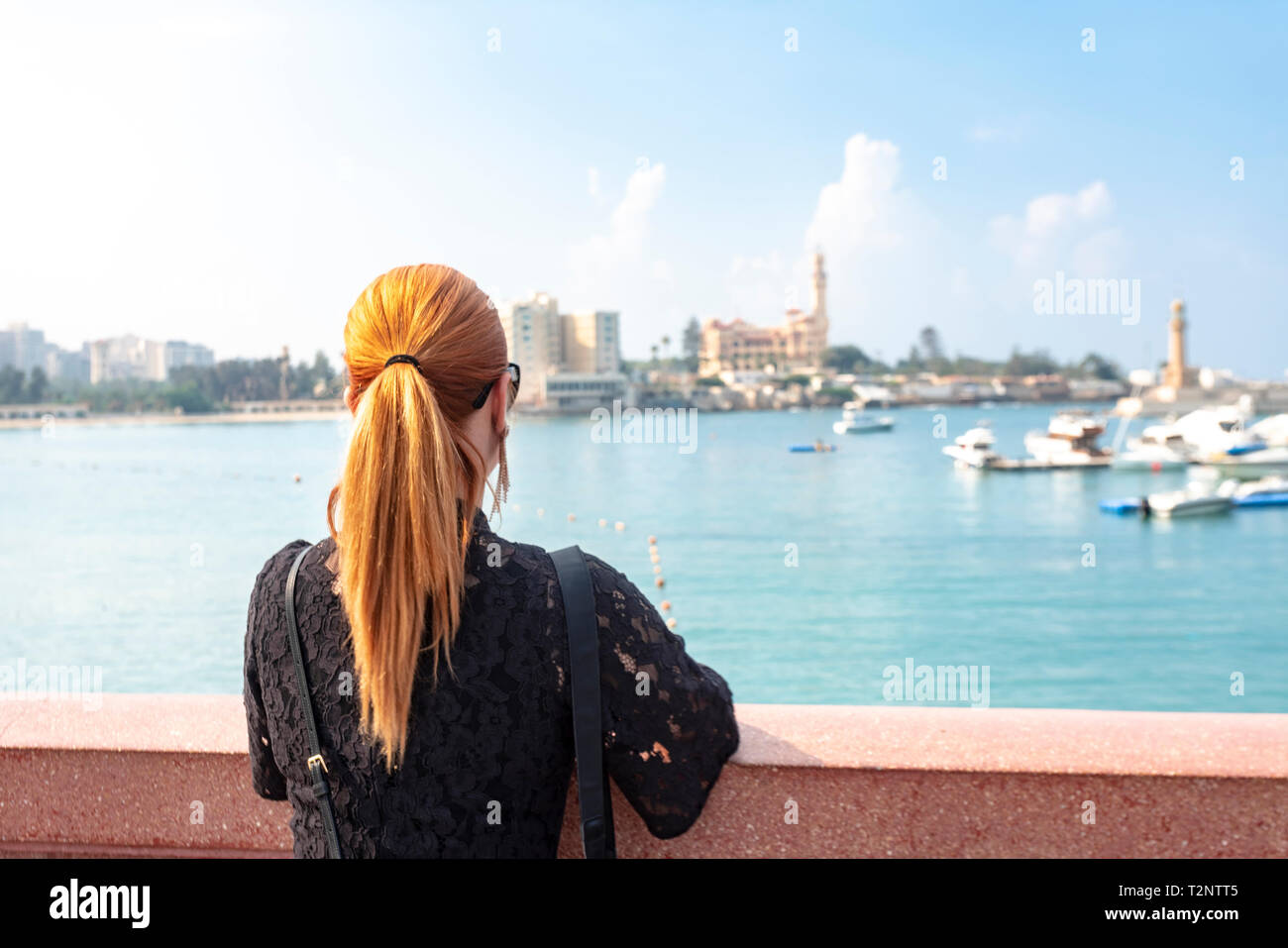 Woman with red hair avec vue sur mer en direction de Montaza palace, vue arrière, Alexandria, Egypte Banque D'Images