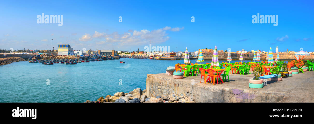 Paysage panoramique avec café de la rue colorée sur le quai du port de pêche à Essaouira. Le Maroc, l'Afrique du Nord Banque D'Images