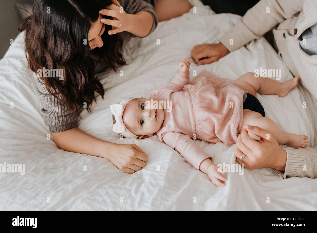 Couple avec bébé fille le lit dans la chambre Photo Stock - Alamy