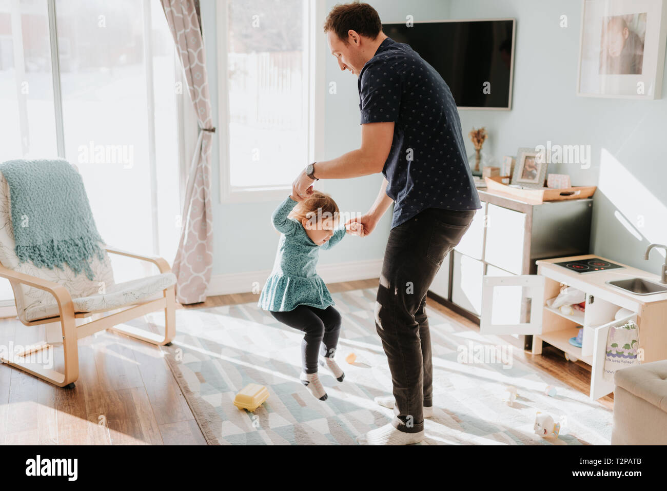 Père jouant avec toddler Fille sur tapis de salon Banque D'Images