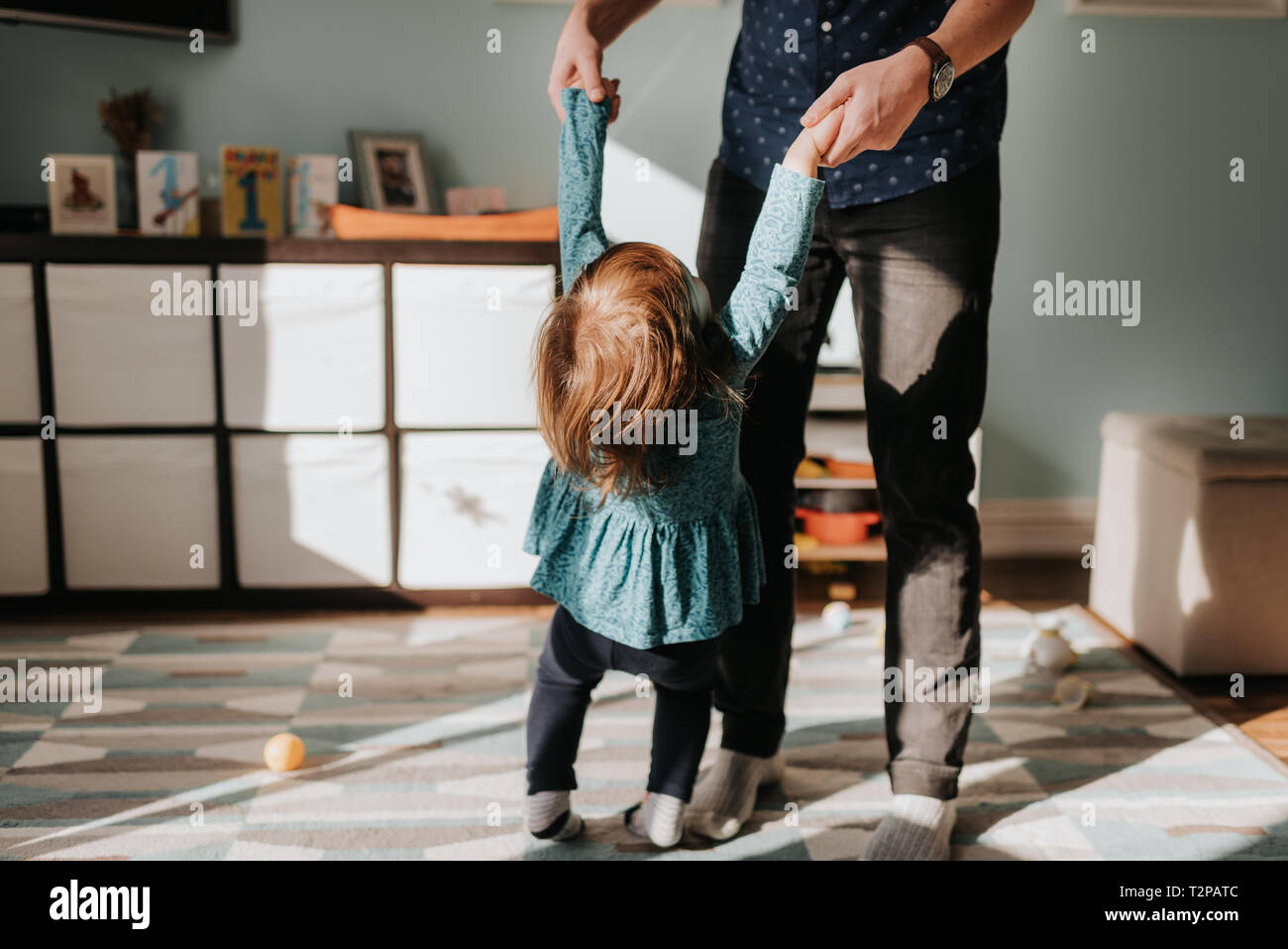 Père jouant avec toddler Fille sur tapis de salon Banque D'Images