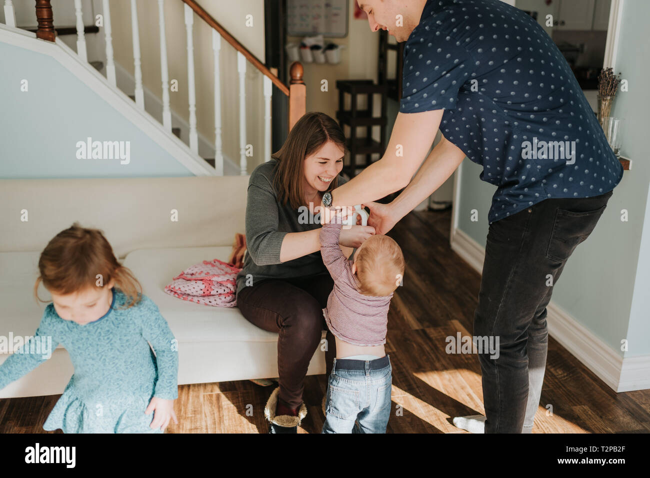 Couple avec bébé garçon et female toddler in living room Banque D'Images