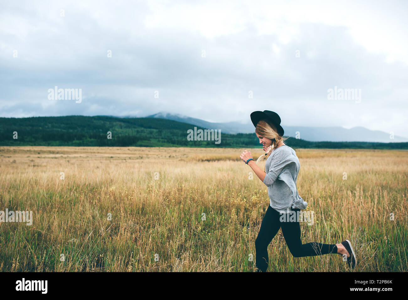 Woman running in wheat field, Edmonton, Canada Banque D'Images
