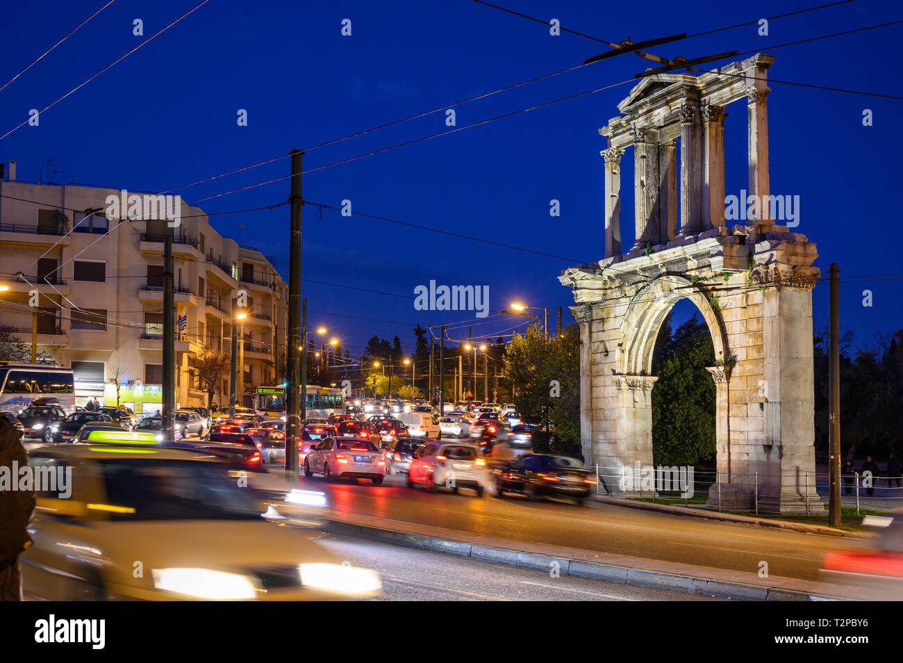 Le trafic lourd en passant l'Arche d'Hadrien sur Leoforos Vasilisis Amalias la nuit, le Centre d'Athènes, Grèce. Banque D'Images