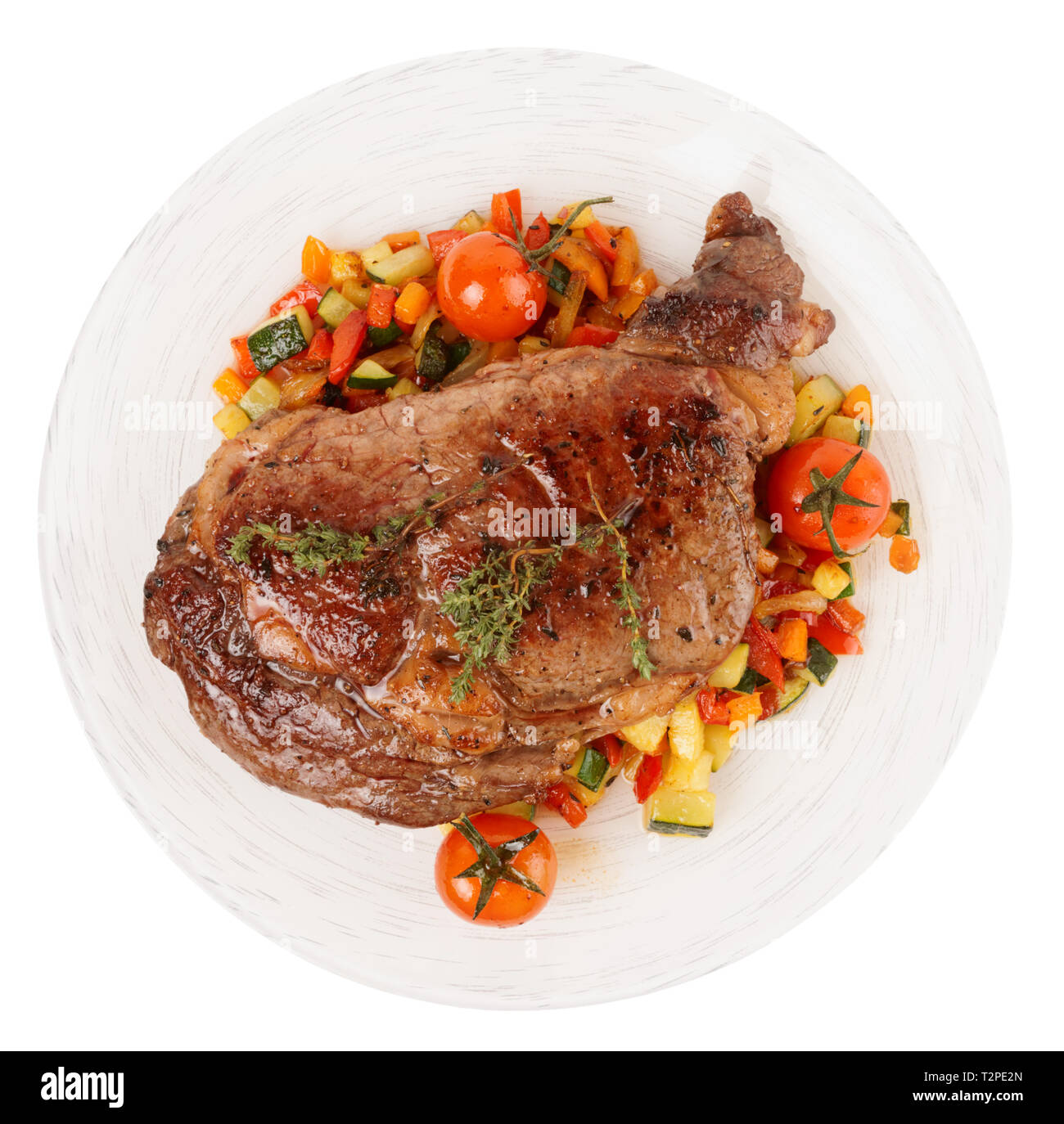 Ribeye Steak savoureux avec des légumes sautées isolé sur fond blanc Banque D'Images