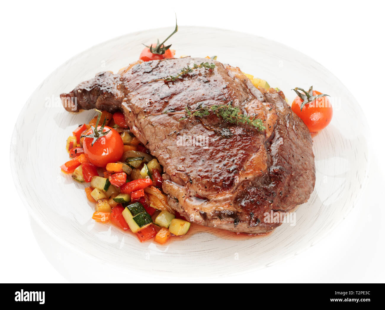 Ribeye Steak savoureux avec des légumes sautées isolé sur fond blanc Banque D'Images