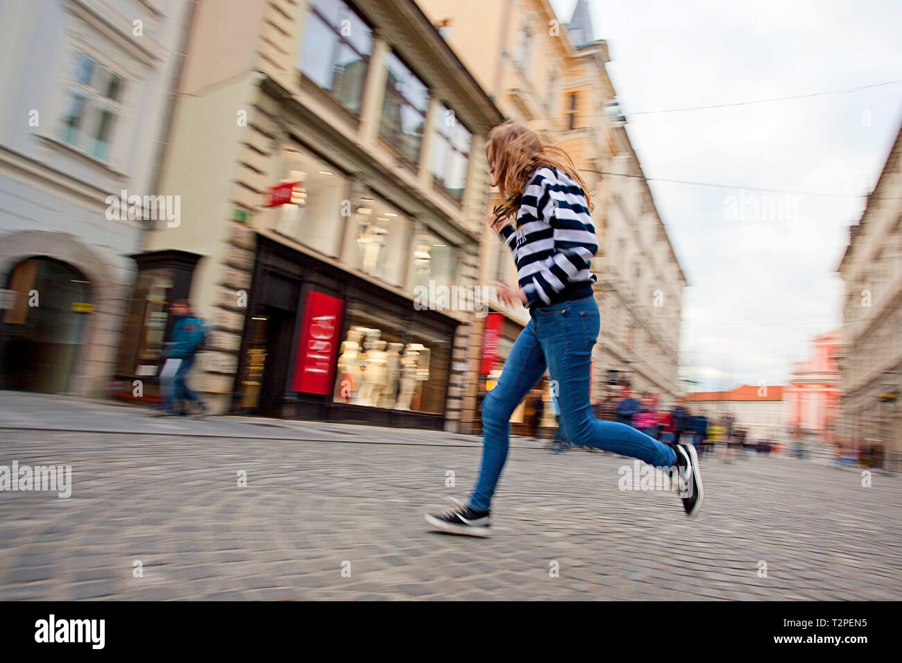 Fille courir dans la rue, Ljubljana, Slovénie Banque D'Images
