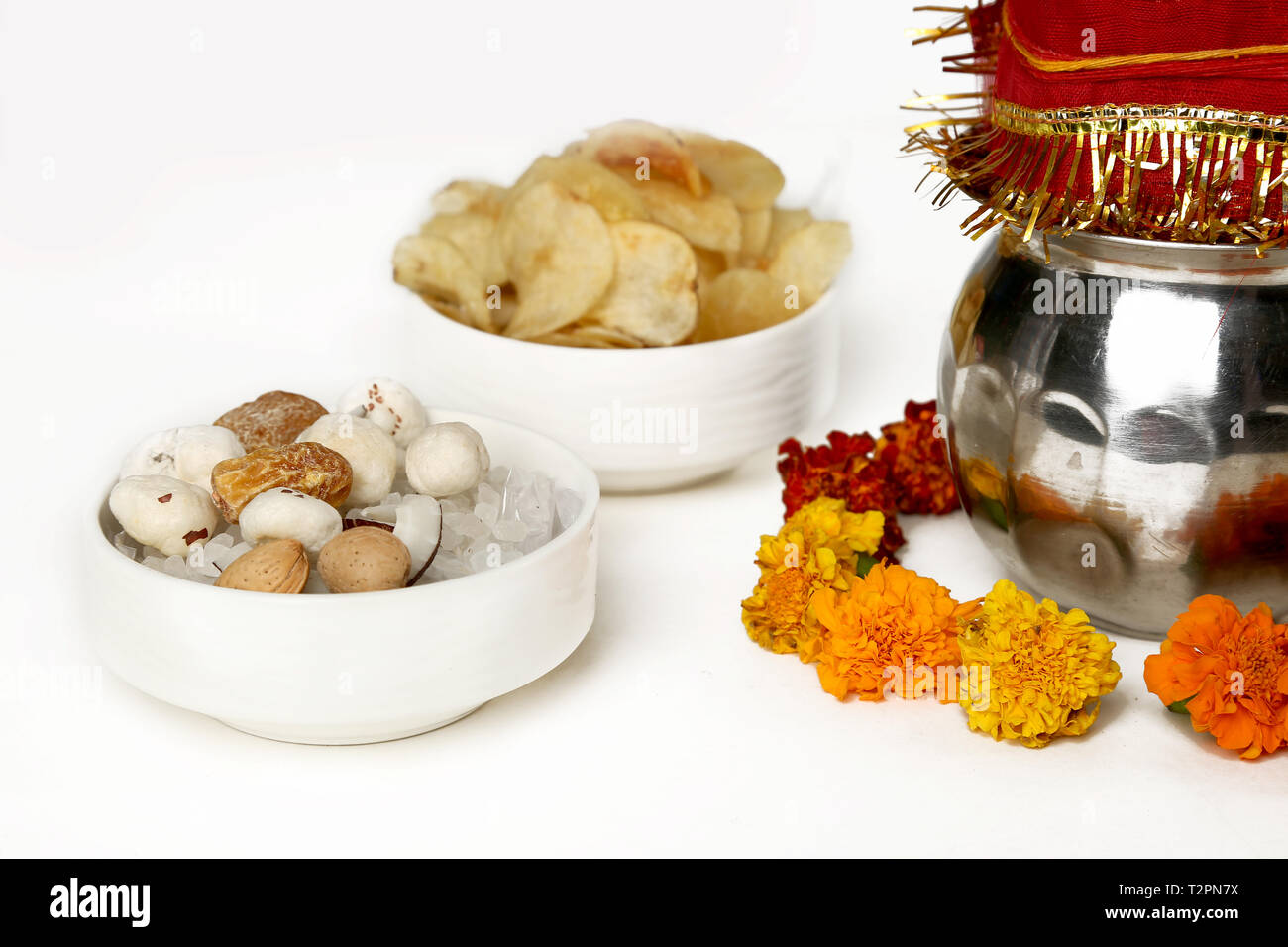Kalash avec noix de coco et chunni avec décoration florale de navratri pooja. Photo de fruits secs et les chips de pomme de terre dans le bol. Isolé sur le bac blanc Banque D'Images
