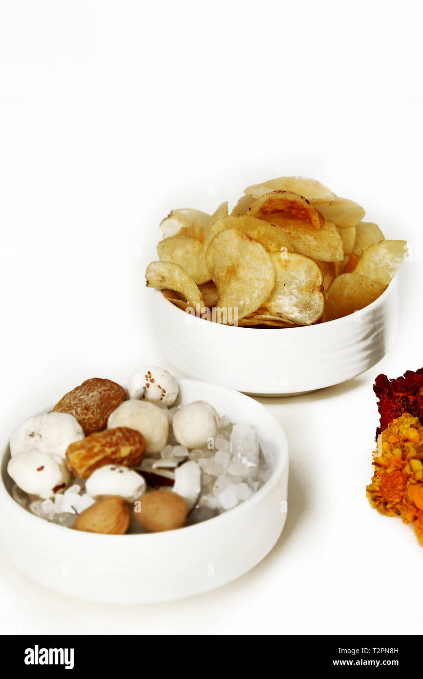 Photo de fruits secs et des jetons dans le bol pour festival navratri. Isolé sur le fond blanc. Banque D'Images